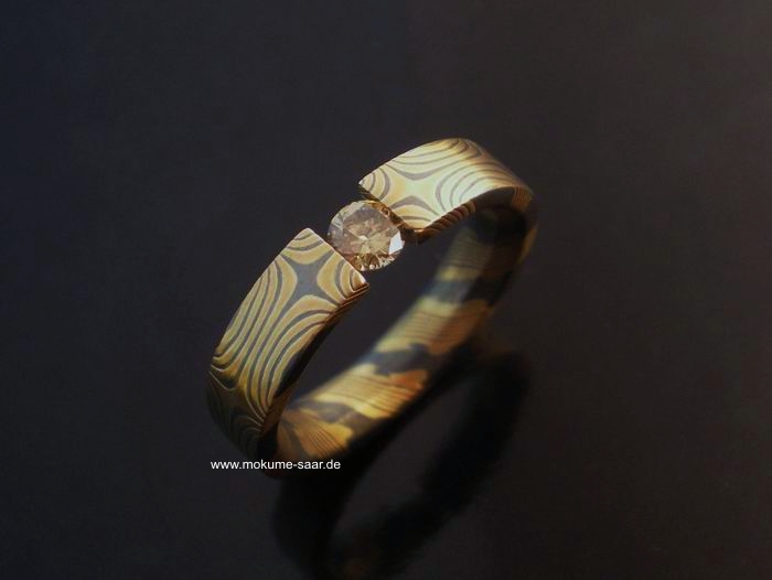 Mokume Gane Ring mit Sternenmuster aus Gold und oxidiertem Silber mit gespanntem Brillant